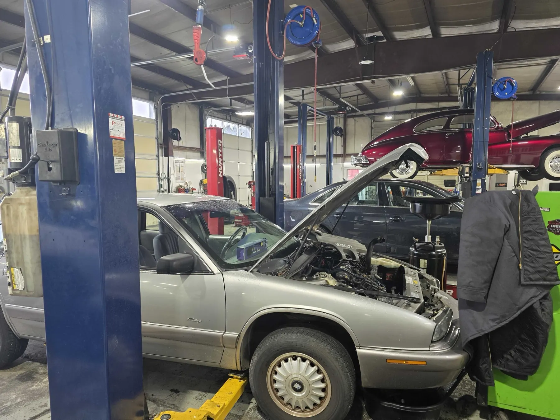 Buick sedan with hood up on the lift at Rob's Automotive Repair Center in Clackamas, Oregon